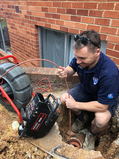 Fix-It Right plumber running a drain camera into a blocked drain